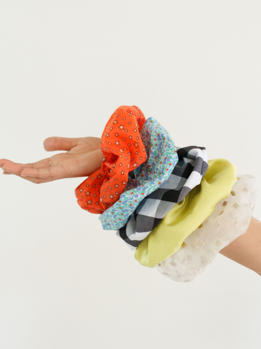 Arm holds a stack of colourful scrunchies